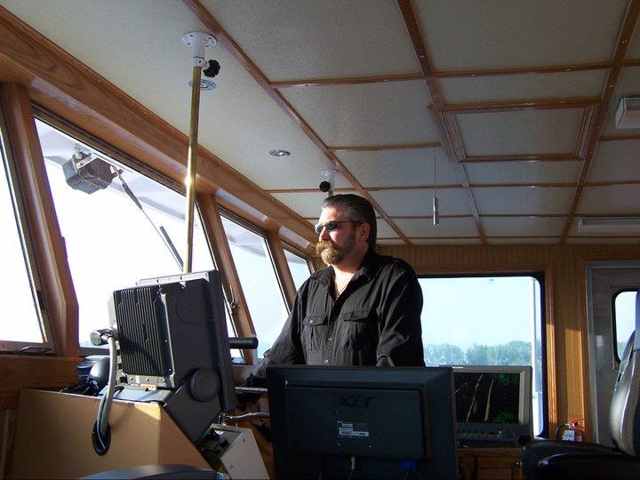 Barge captain piloting tugboat